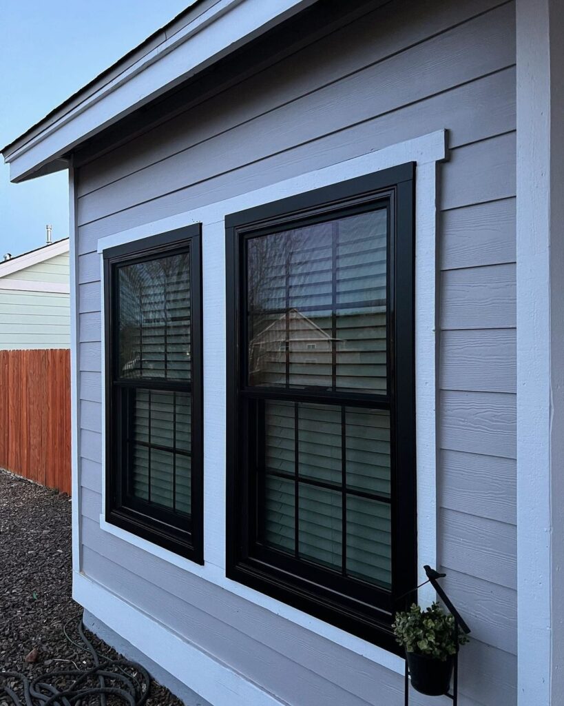 Black grid double-hung windows on light gray home exterior