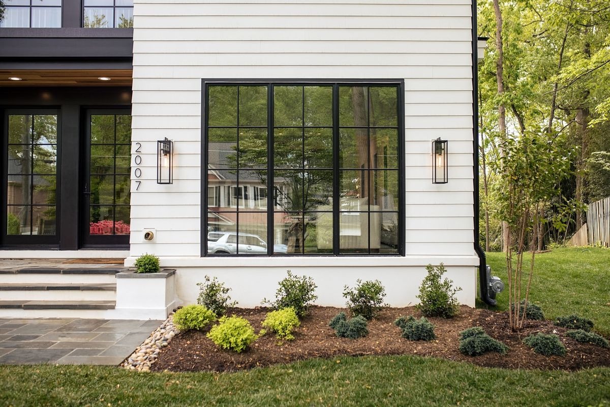 Modern white house exterior with large black grid windows