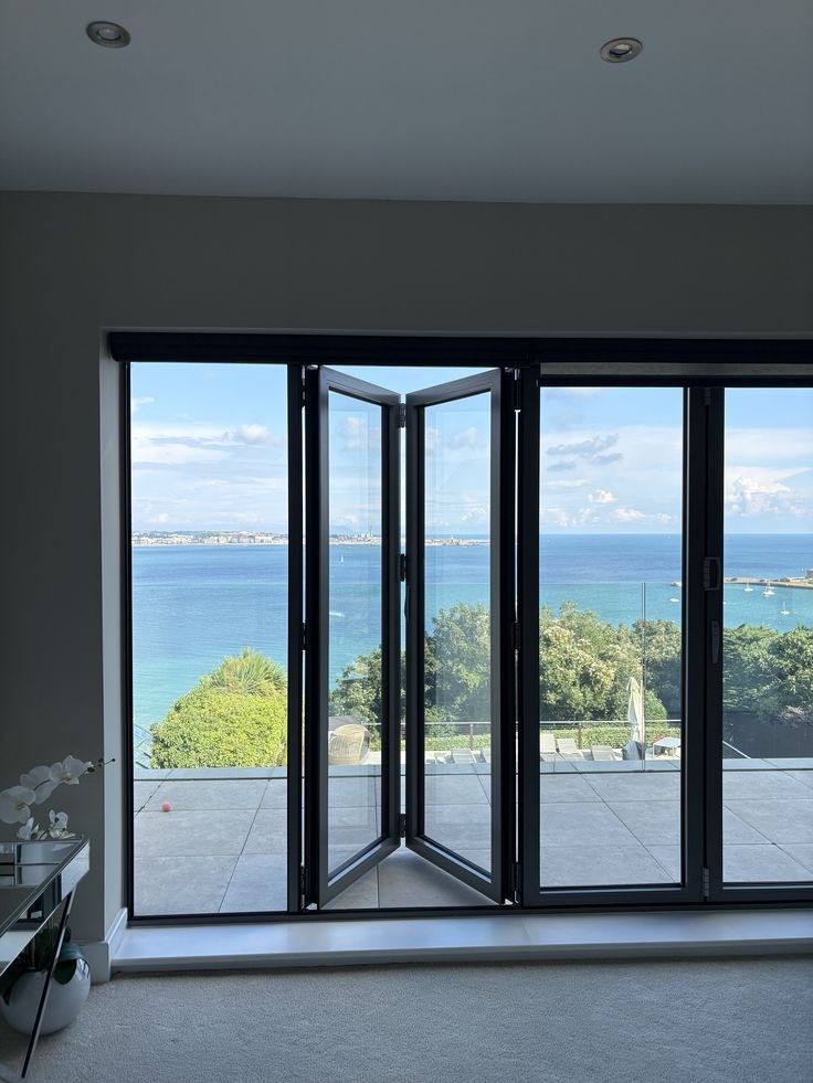 Modern bifold patio doors opening to stunning oceanfront view
