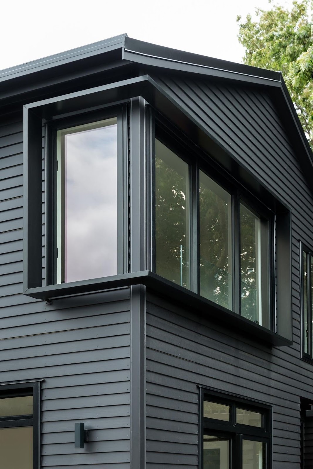 Modern black exterior home with large energy-efficient windows